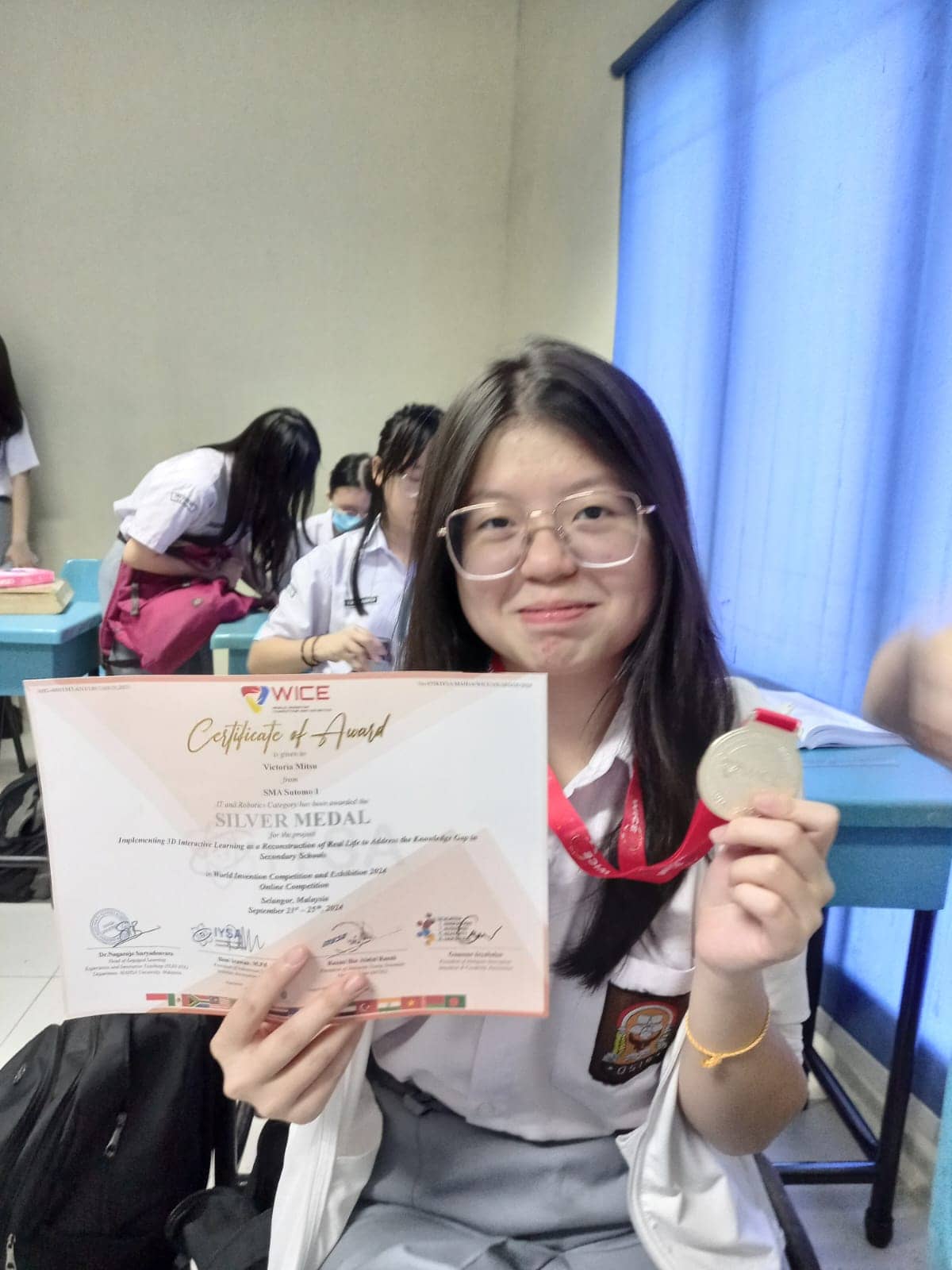 Victoria holding her WICE silver medal and certificate